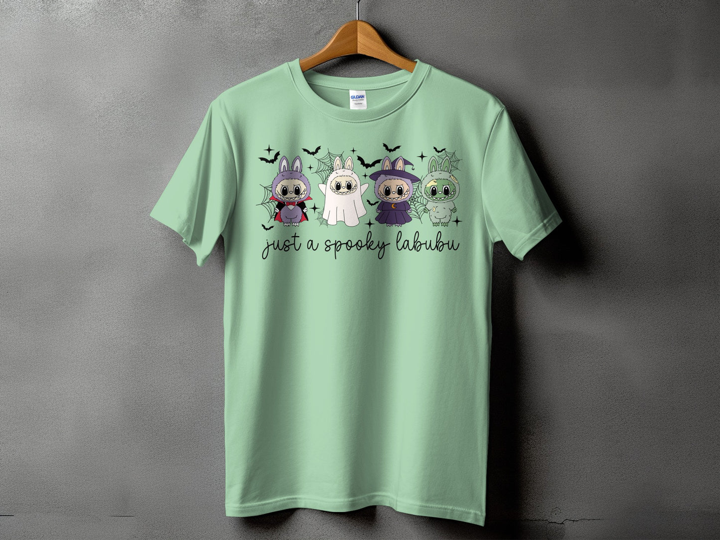 Light green t-shirt with four spooky Halloween characters and text "just a spooky labubu".