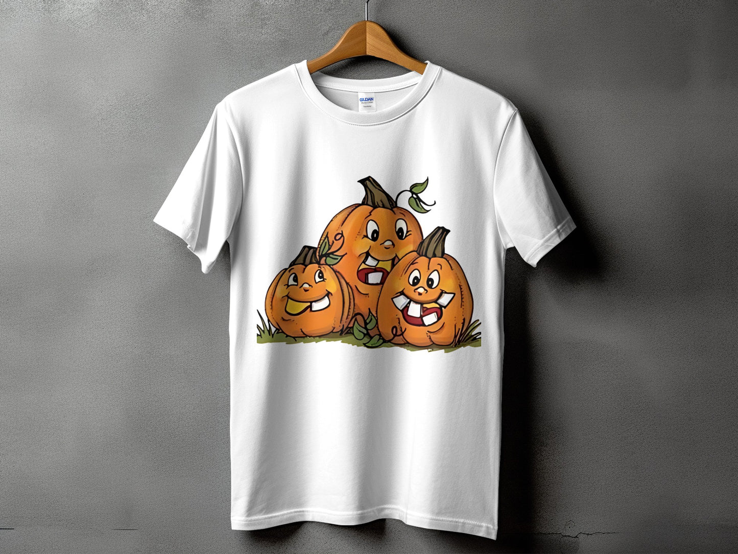 White t-shirt featuring a cartoon illustration of three happy pumpkins on grass.