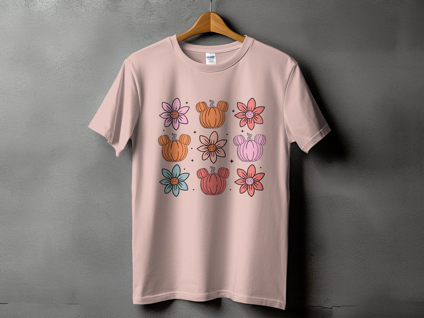 Pink t-shirt with a grid of flowers and pumpkins with mouse ears.
