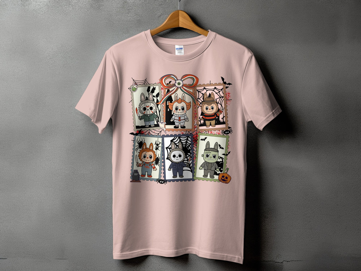 Pink t-shirt with six Halloween-themed character stamp graphics and a bow.