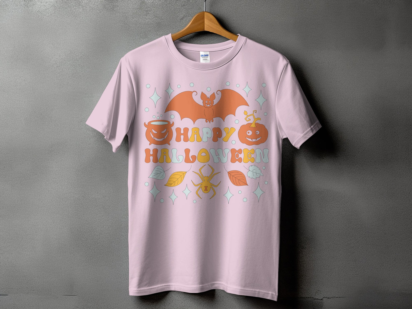 Pink t-shirt with "Happy Halloween" text, bat, pumpkins, spider, and leaves graphic.