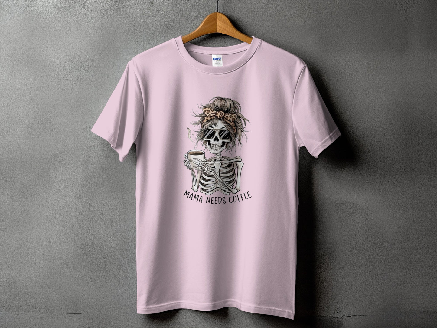 Pink t-shirt with skeleton graphic holding coffee and text "Mama Needs Coffee".