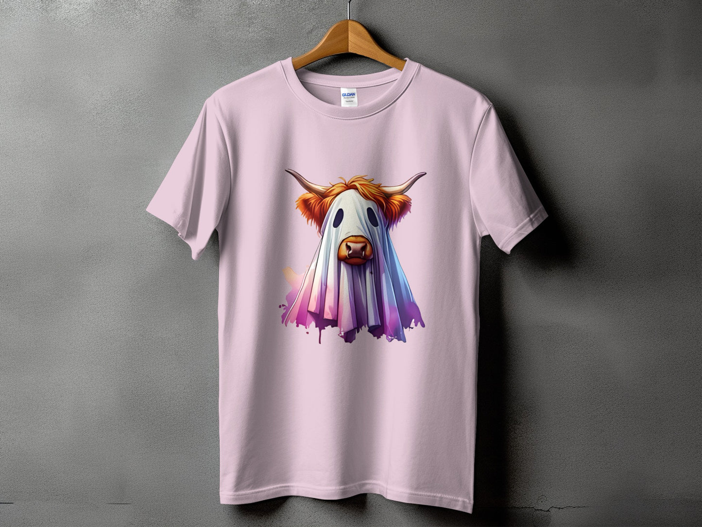 Highland cow wearing a ghost costume graphic on a light pink t-shirt.