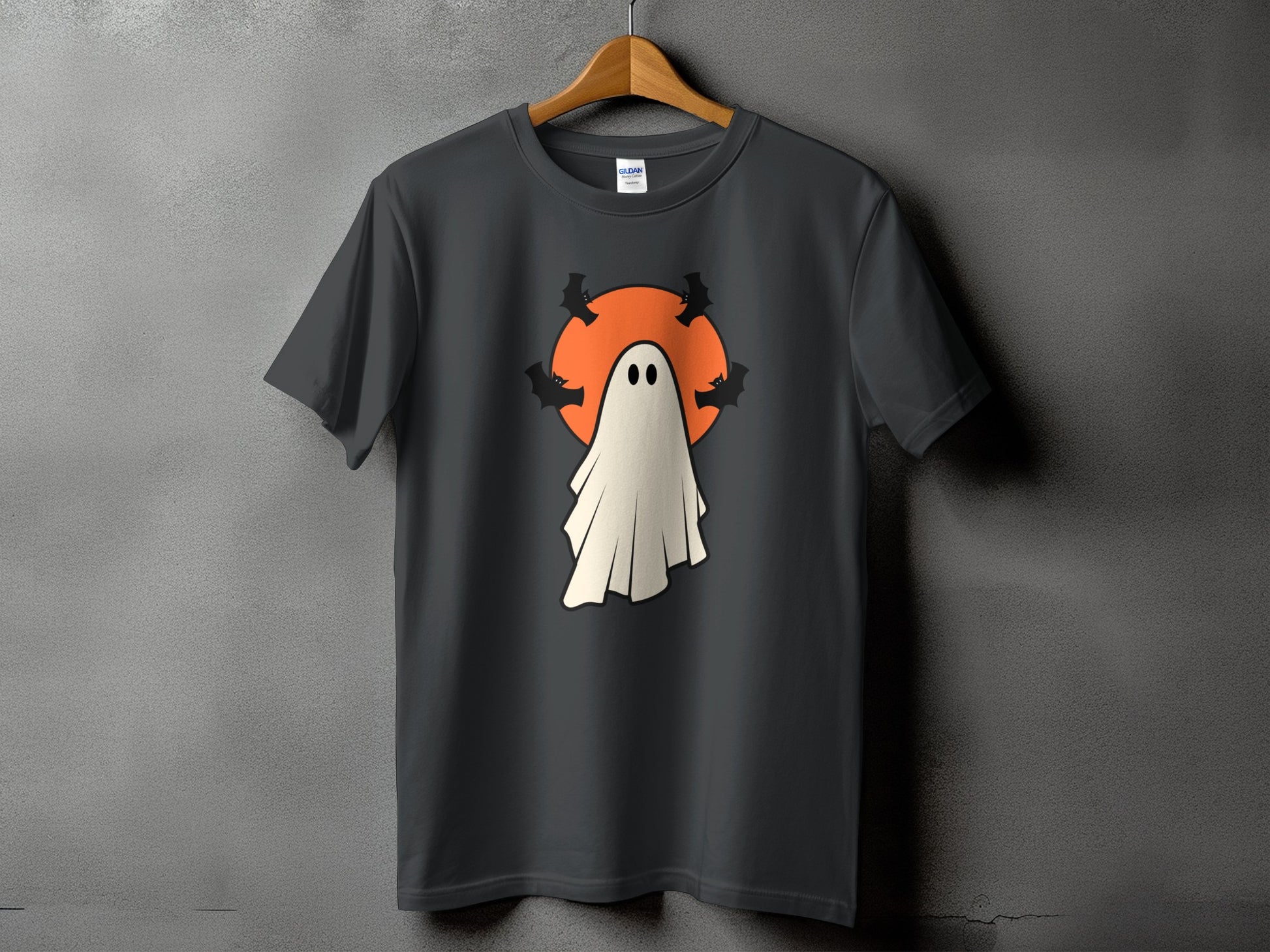 Dark t-shirt with a white ghost and bats design on an orange circle.