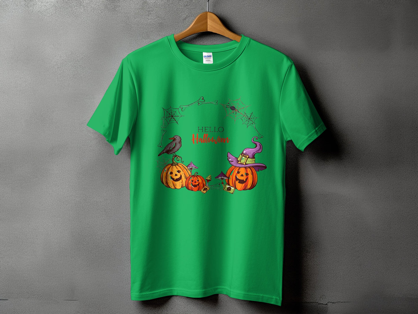 Green t-shirt with Halloween pumpkins, witch hat, bird, spiders, and "Hello Halloween" text.