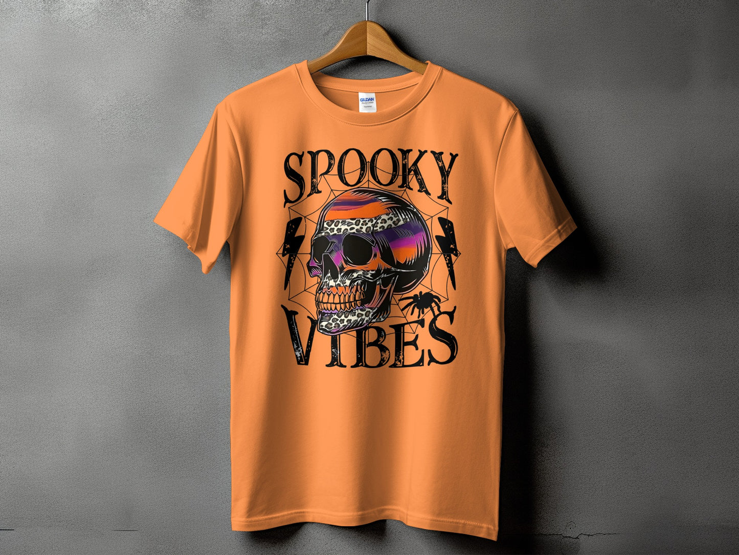Orange t-shirt with spooky skull, spider, and text "SPOOKY VIBES" graphic.