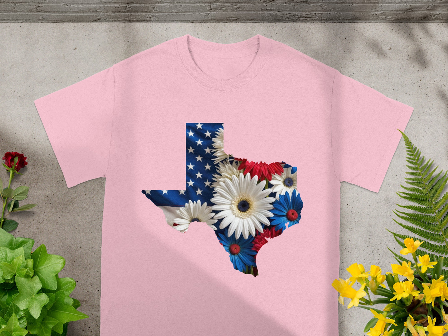 Pink t-shirt with Texas outline filled with American flag and flowers.