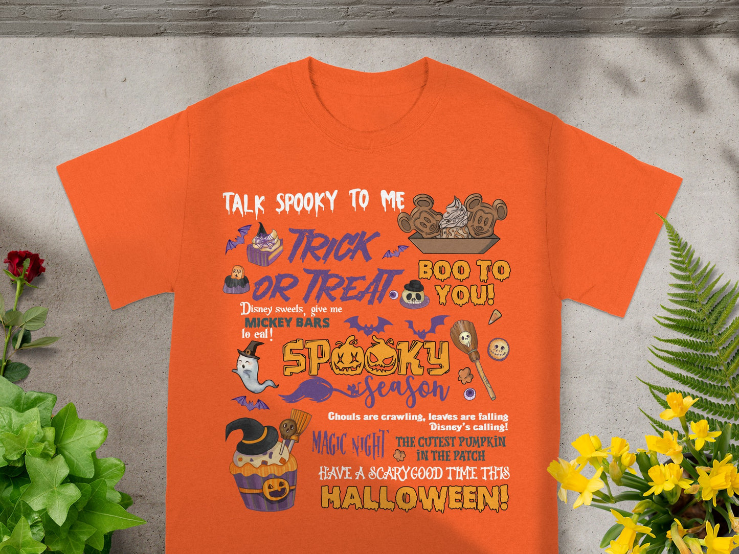 Orange t-shirt with Halloween graphic featuring text "Talk Spooky to Me", "Trick or Treat", and "Spooky Season".