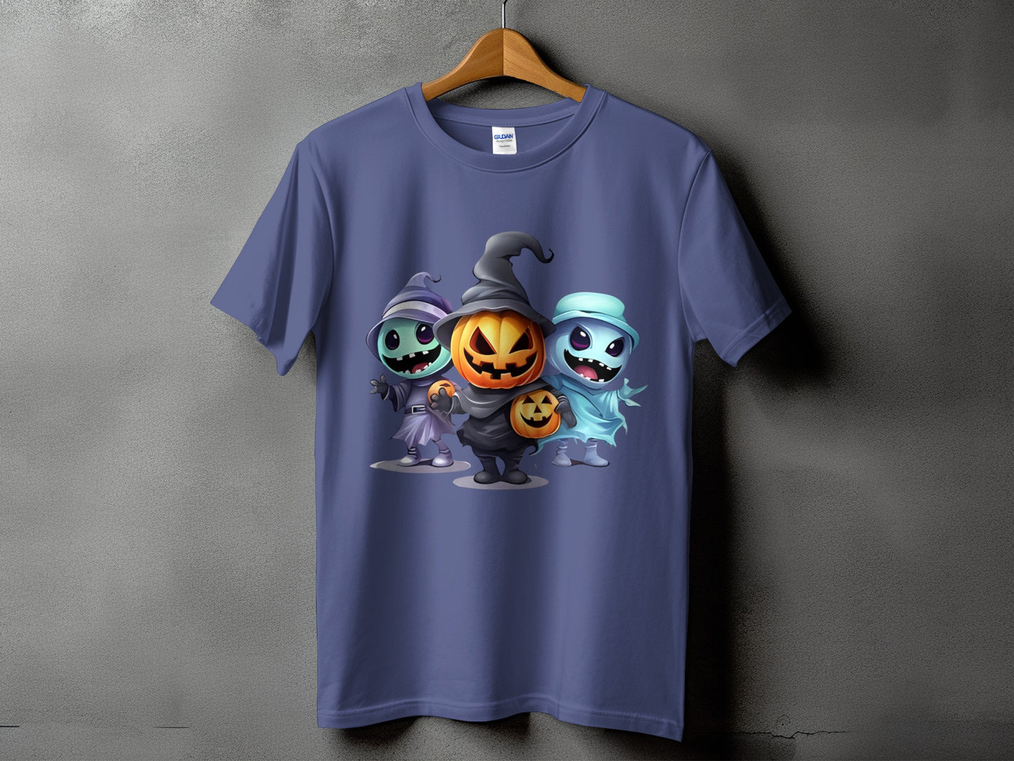 Purple t-shirt featuring three cartoon Halloween characters: a witch, a jack-o'-lantern, and a ghost.