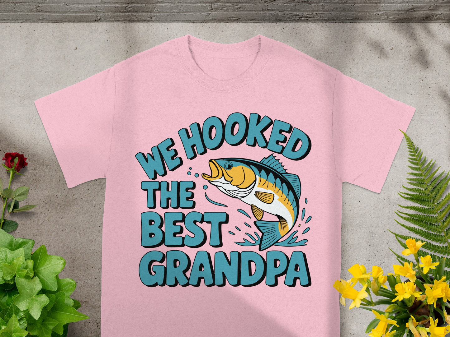 Pink t-shirt with "We Hooked The Best Grandpa" and a jumping fish graphic.