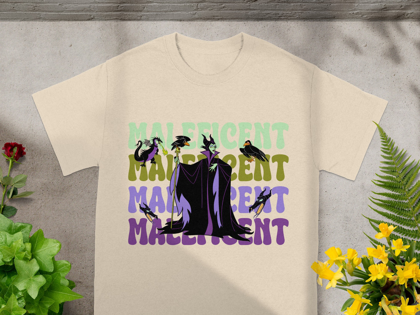 Maleficent graphic on a tan t-shirt with green and purple text.