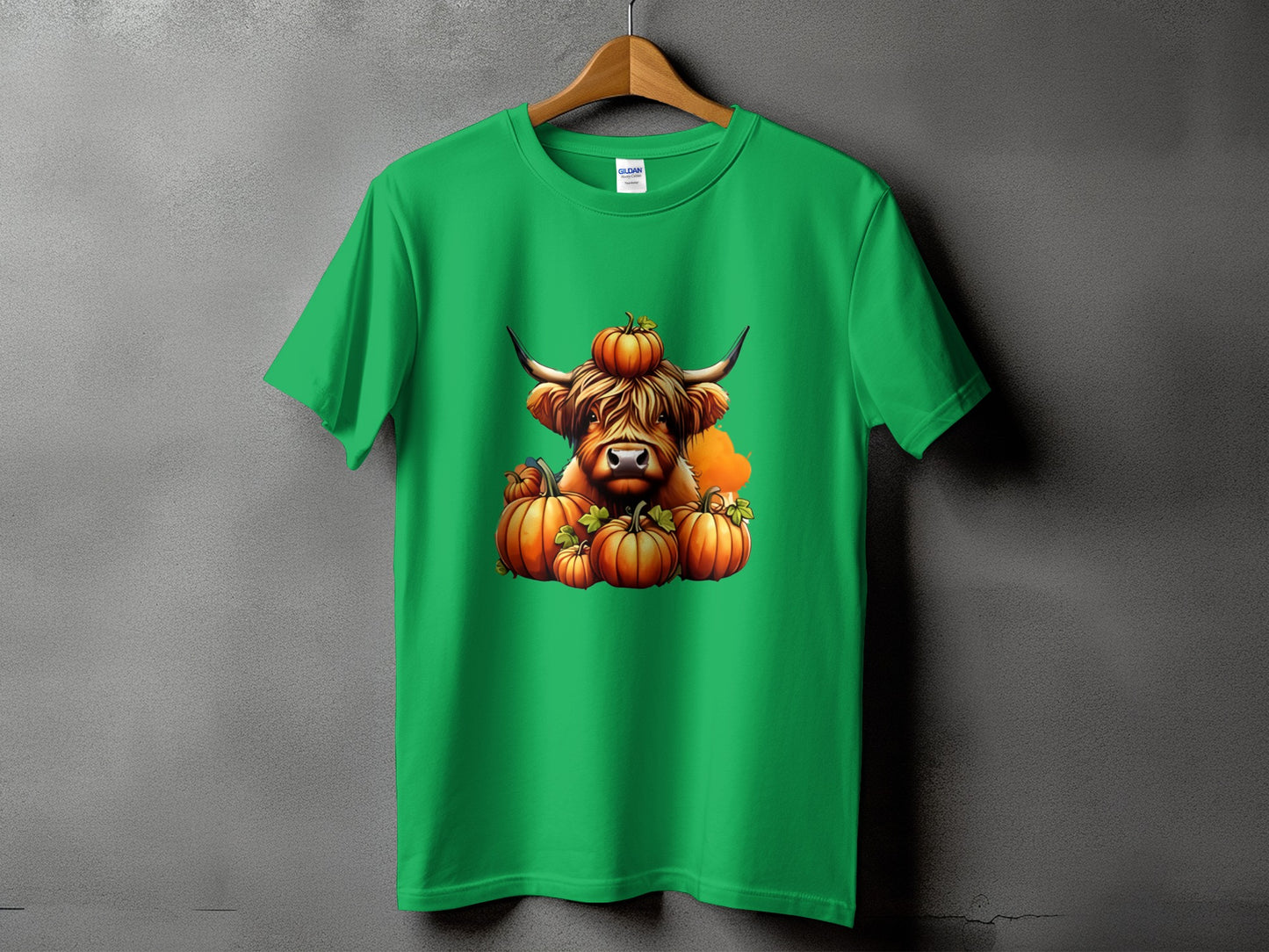 Green t-shirt with a Highland cow and pumpkins graphic.