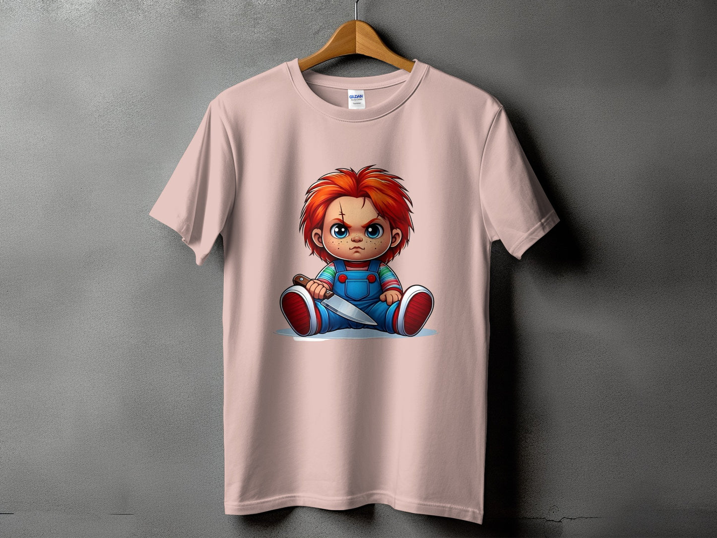 Pink t-shirt with cartoon Chucky doll holding a knife graphic.