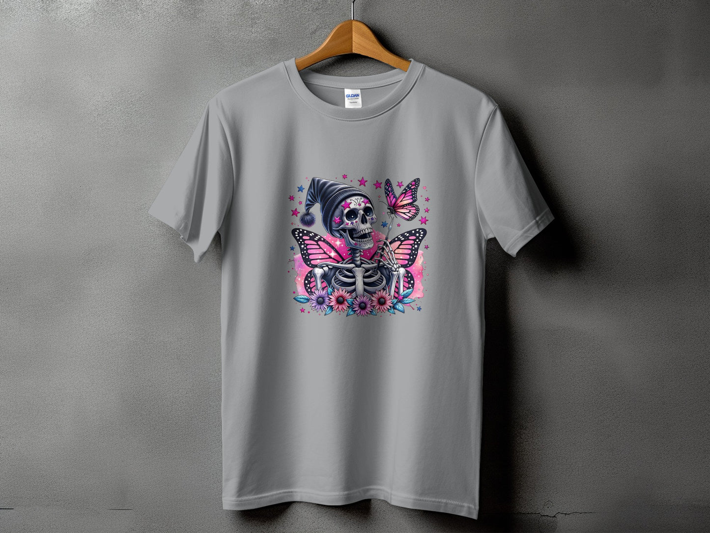 Gray t-shirt with a skeleton wearing a hat, pink butterflies, and flowers graphic.