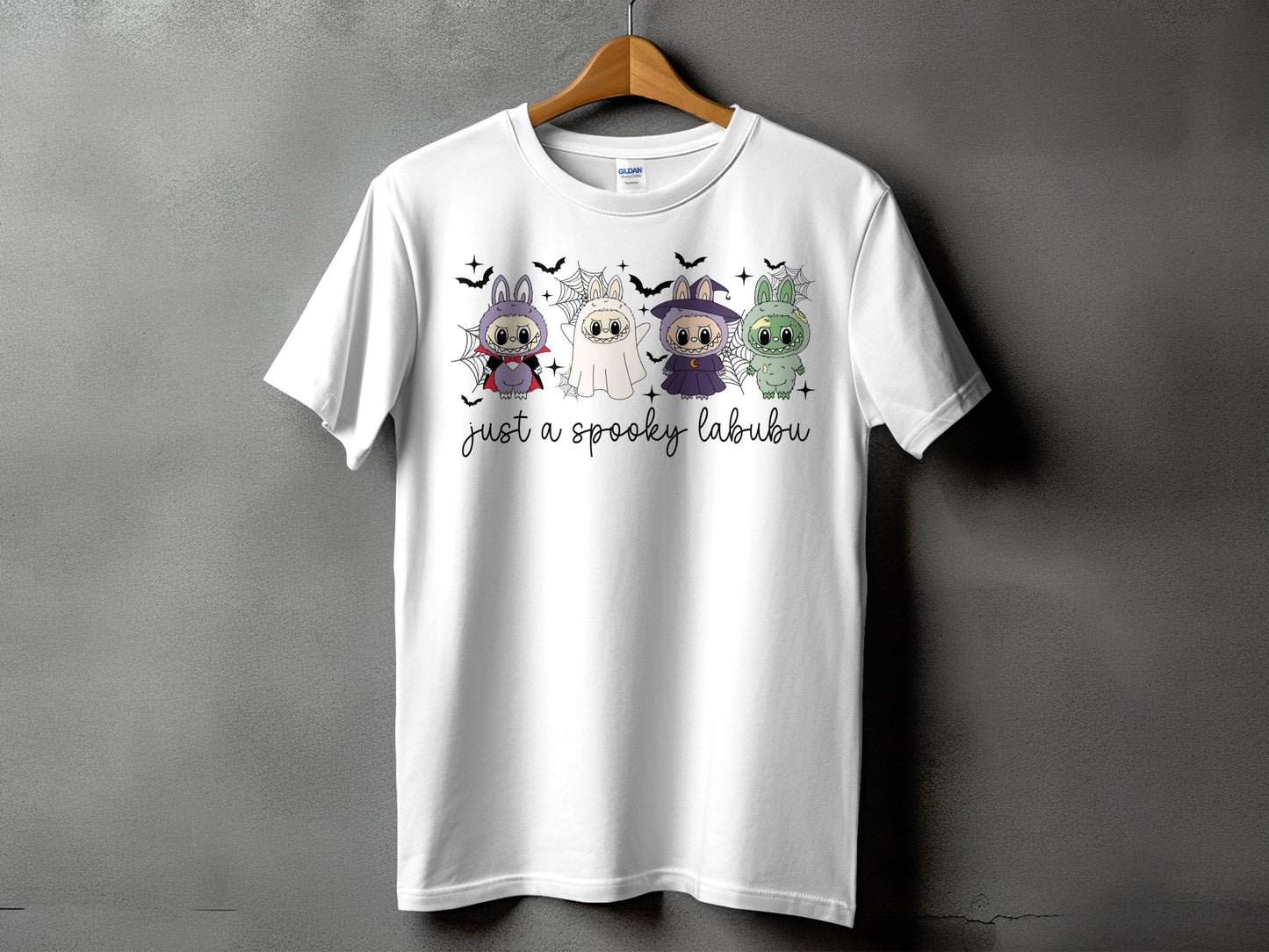 White t-shirt with four Halloween-themed Labubu characters and text.