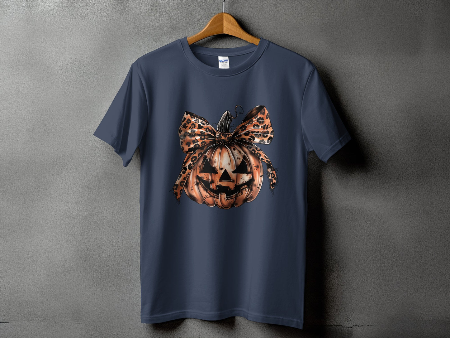 Navy t-shirt with a jack-o'-lantern graphic featuring a leopard print bow.