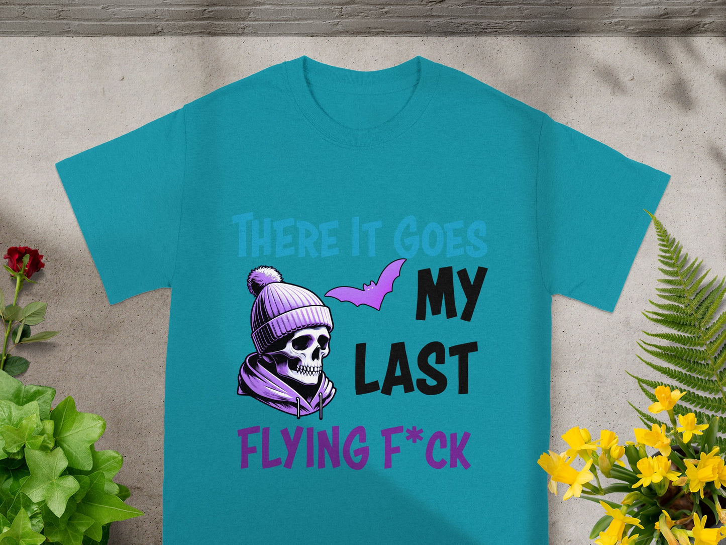 Teal t-shirt with skull, bat, and text "There it goes my last flying f*ck".