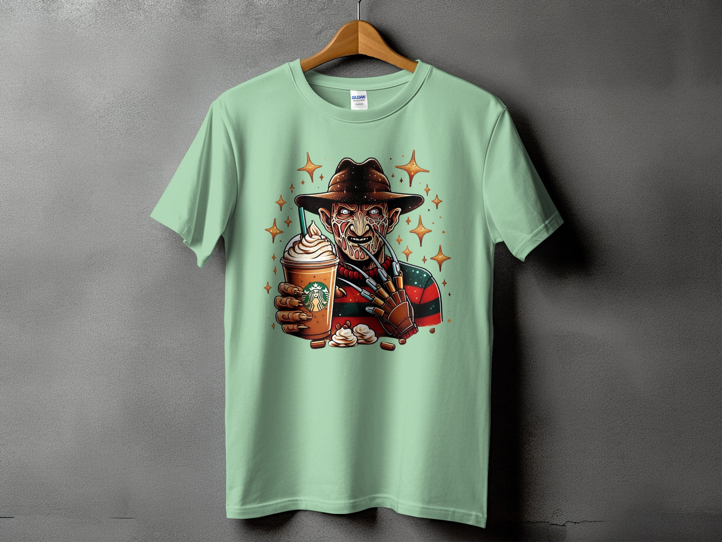 Freddy Krueger holding a Starbucks drink with cream and stars on a light green t-shirt.