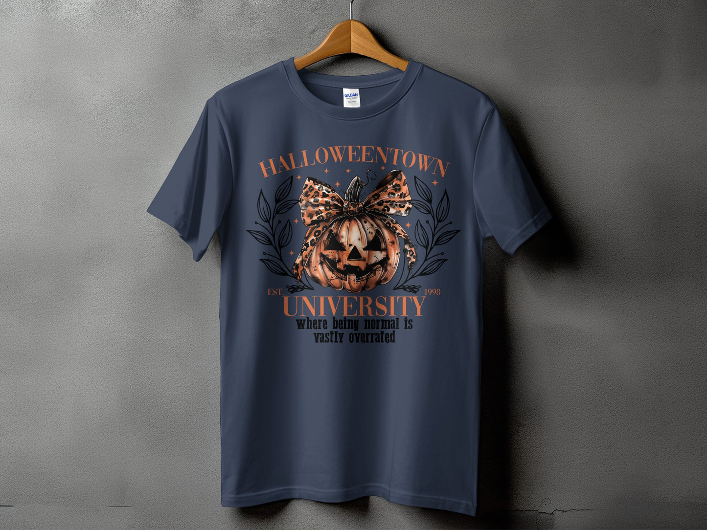Navy t-shirt with a Halloween graphic featuring a pumpkin, bow, and text.