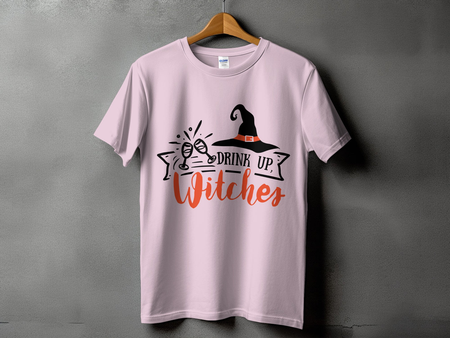 Pink t-shirt with "Drink Up, Witches" and witch hat graphic.