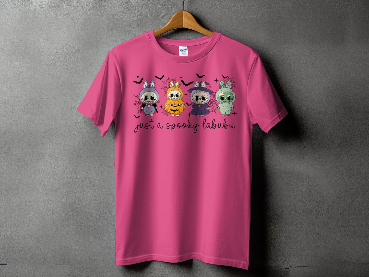 Pink t-shirt with four Halloween-themed cartoon characters and text "just a spooky labubu".