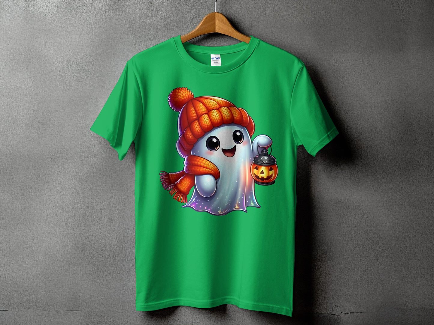 Green t-shirt featuring a cartoon ghost in a knit hat and scarf holding a jack-o'-lantern.