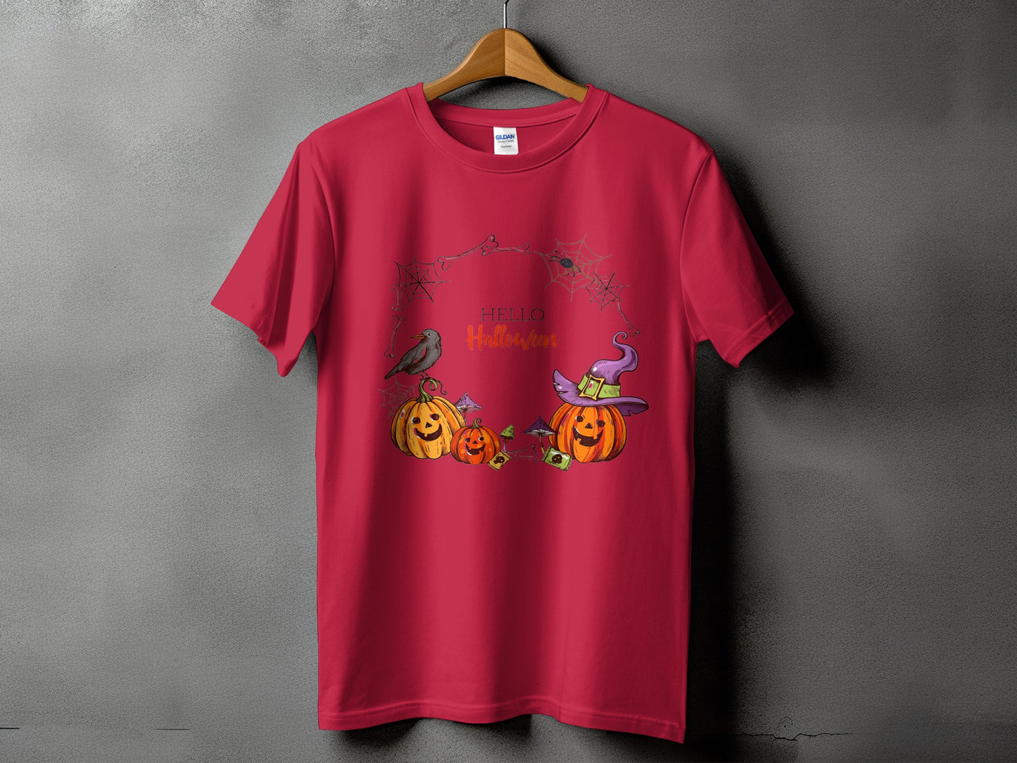 Red t-shirt with Halloween graphic featuring pumpkins, witch hat, bird, and spiderwebs.