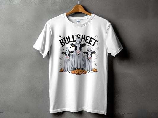 White t-shirt with three cows in ghost costumes and pumpkins, text says "BULL SHEET".