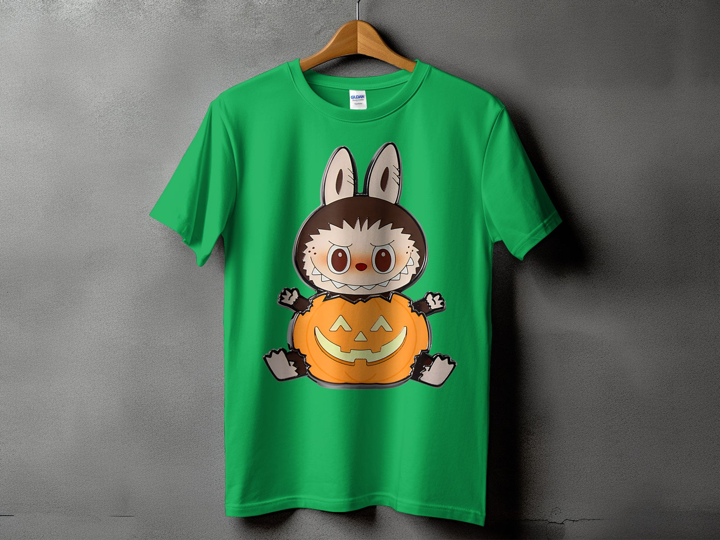 Green t-shirt with a cartoon creature wearing a pumpkin costume.
