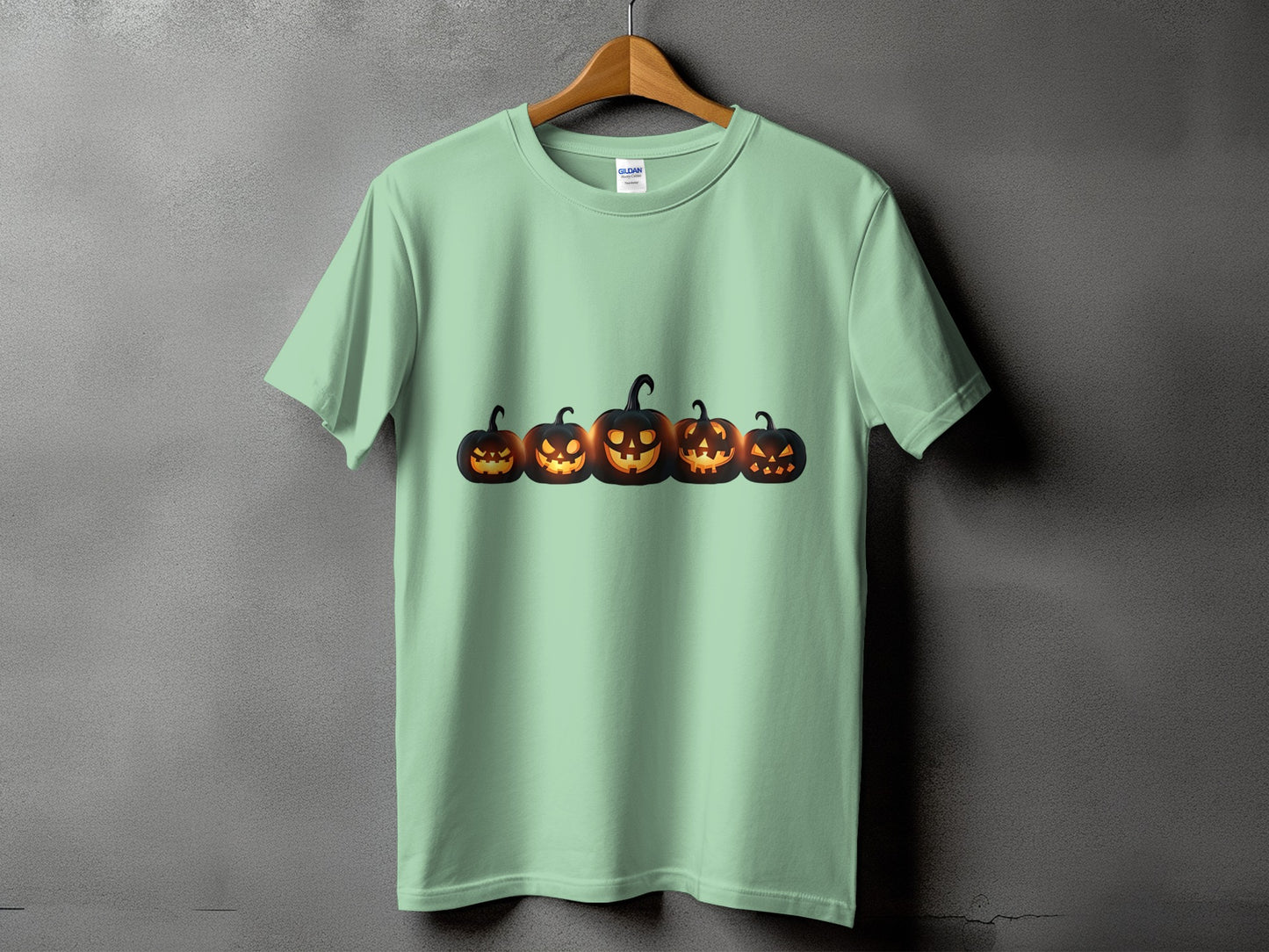 Light green t-shirt with a row of glowing jack-o'-lanterns across the chest.