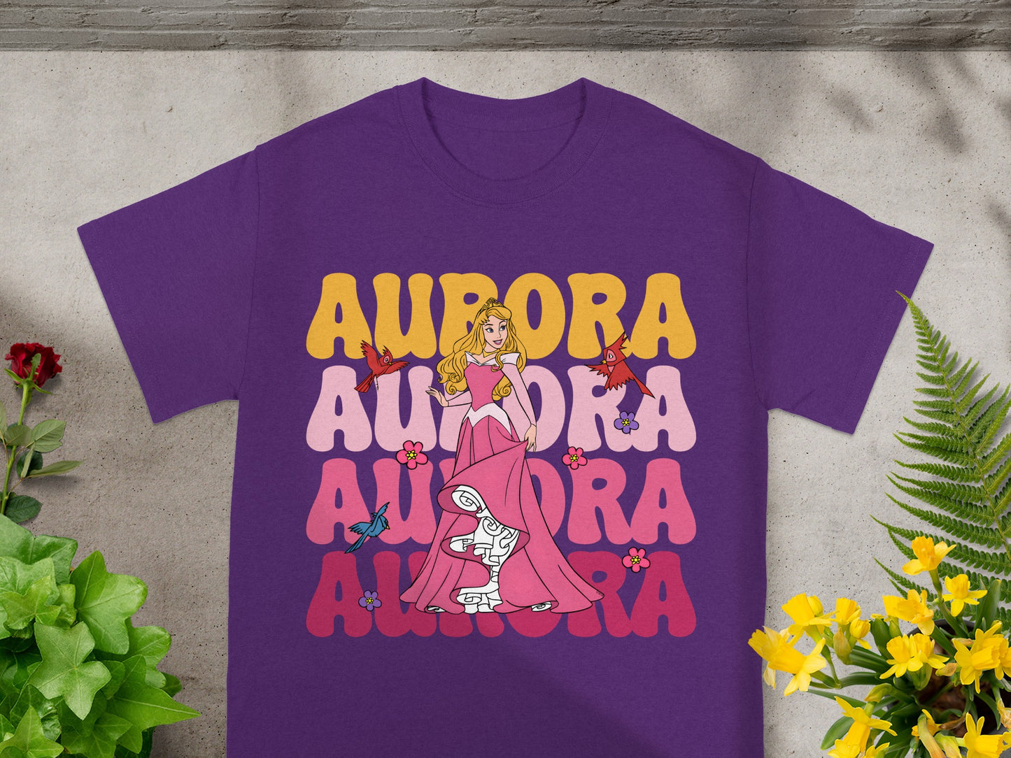 Purple t-shirt with Aurora in pink and yellow text and graphics.