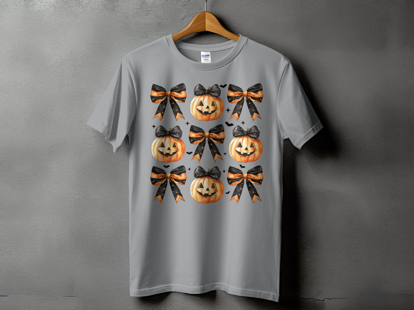 Gray t-shirt with a pattern of pumpkins and black and orange bows.