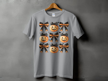 Gray t-shirt with a pattern of pumpkins and black and orange bows.