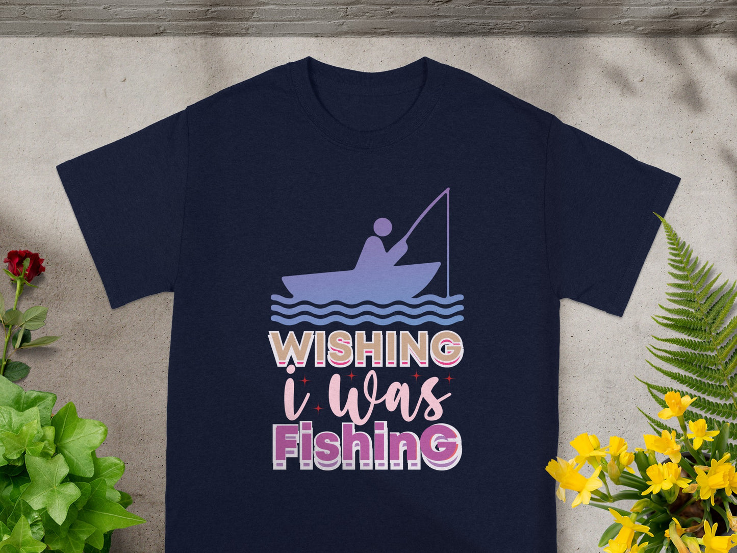 Dark t-shirt with a graphic of a person in a boat fishing, text reads "Wishing i was Fishing".