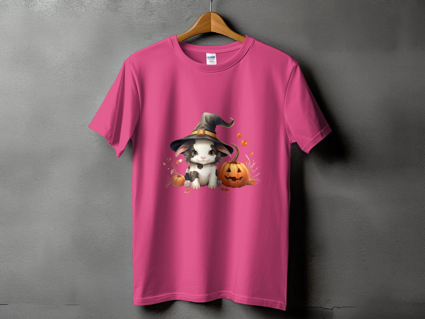 Pink t-shirt with a cartoon bunny wearing a witch hat and sitting by pumpkins.