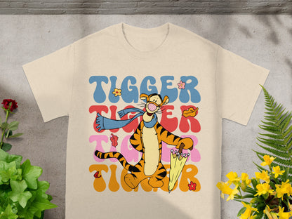 Tigger from Winnie the Pooh character on a cream t-shirt with colorful wavy text.