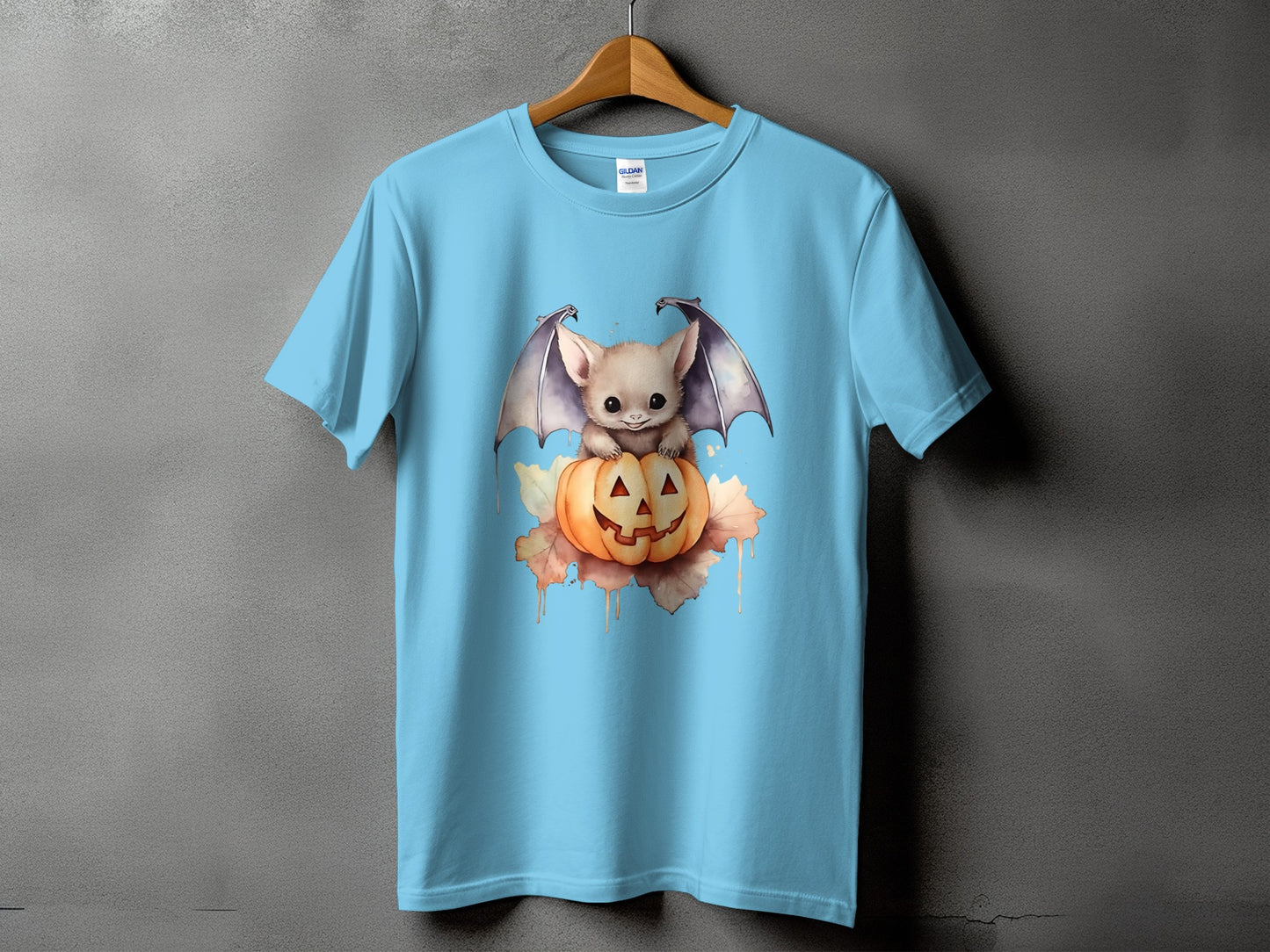 Light blue t-shirt with a cute baby bat sitting on a jack-o'-lantern.
