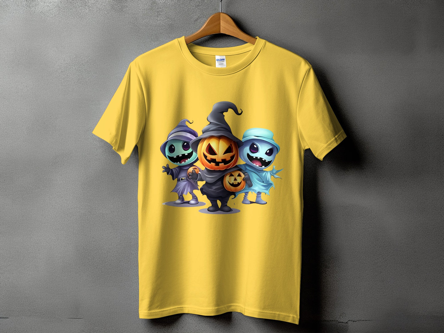 Yellow t-shirt with three cute Halloween characters: a pumpkin, a witch, and a ghost.