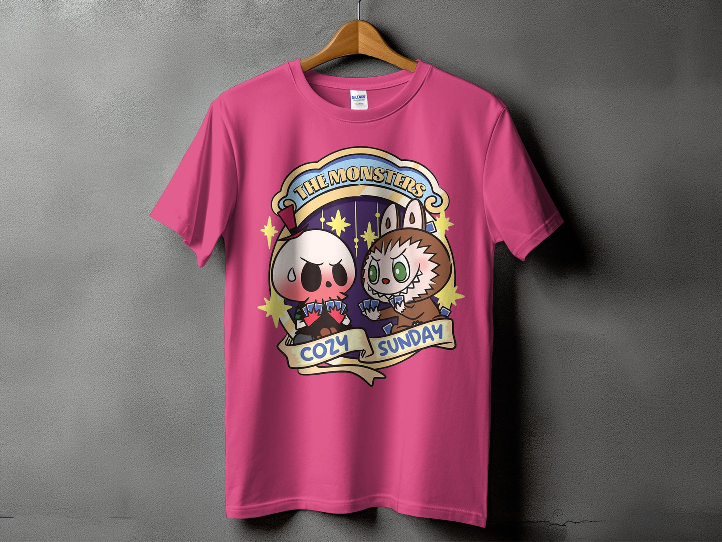 Pink t-shirt featuring cartoon skull and werewolf playing cards with "The Monsters Cozy Sunday" text.