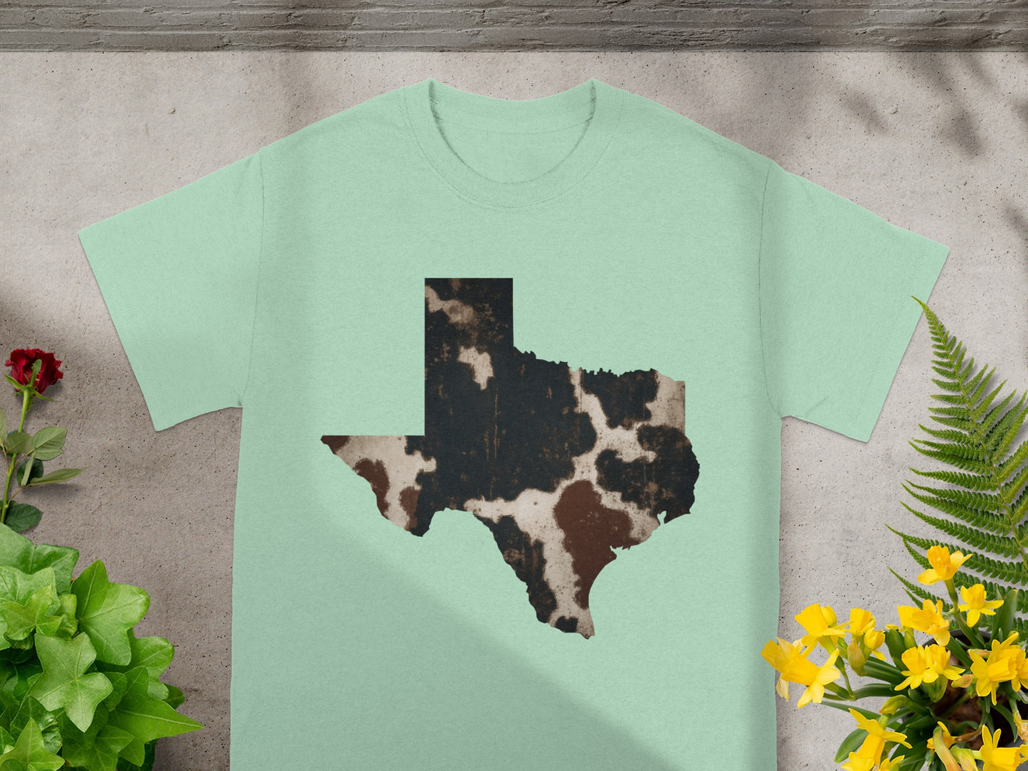 Mint t-shirt with a cowhide pattern Texas outline graphic.