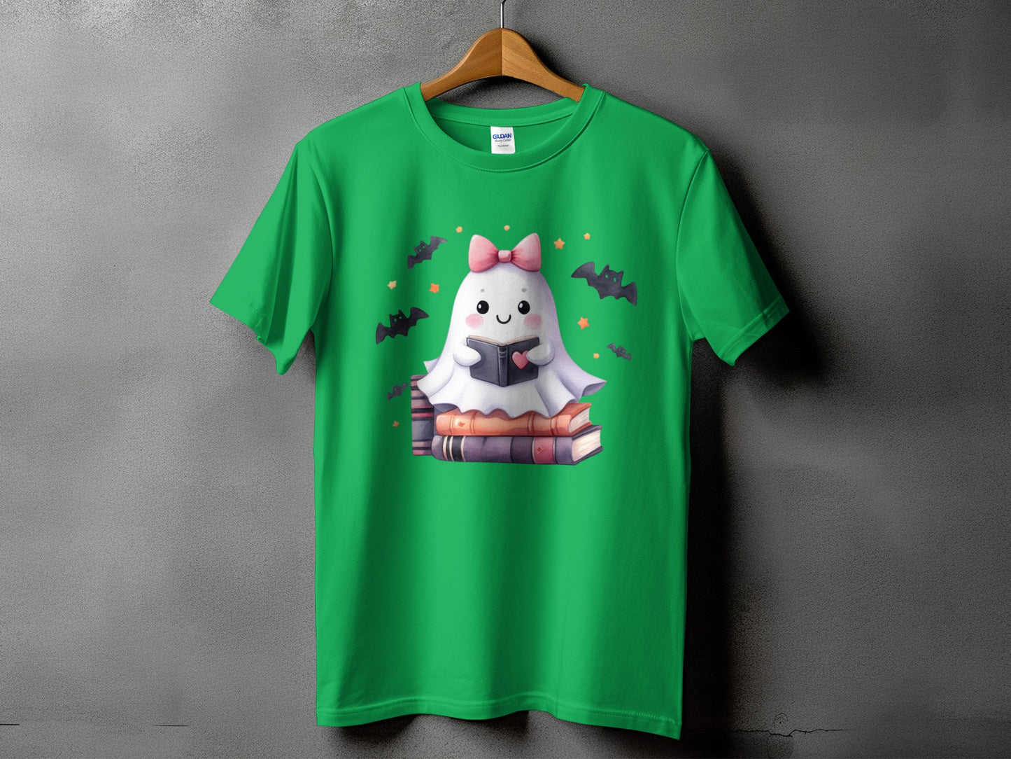 Green t-shirt with a cartoon ghost reading a book surrounded by bats and stars.