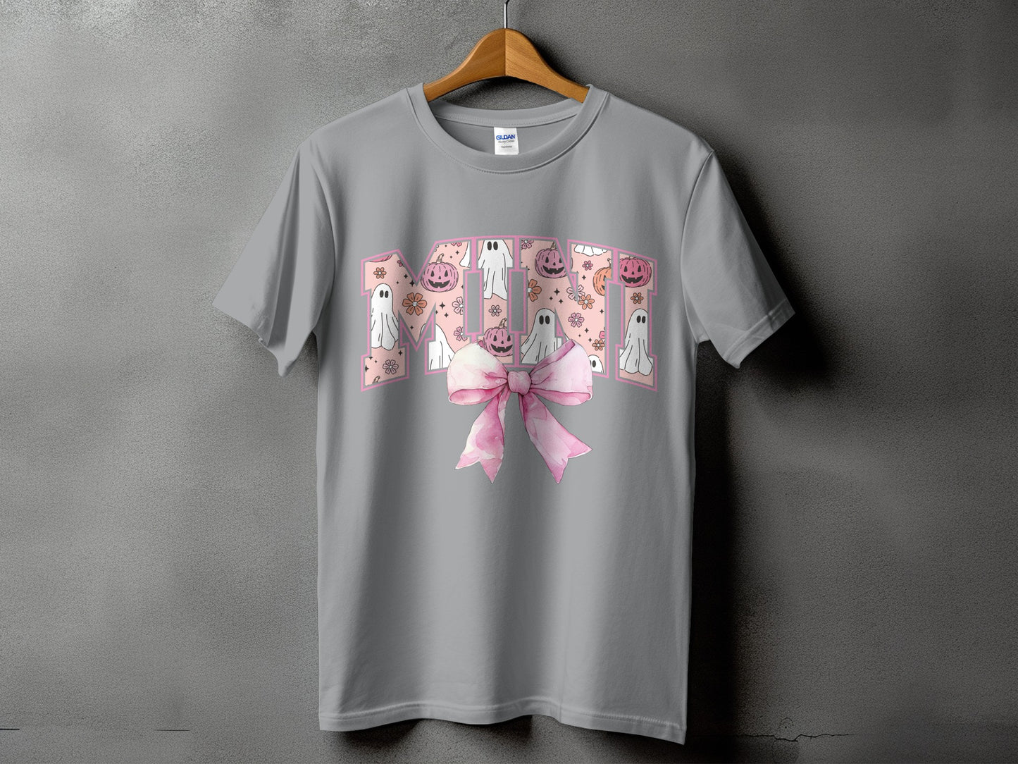 Grey t-shirt with "MOM" text featuring Halloween ghosts and pumpkins, and a pink bow.