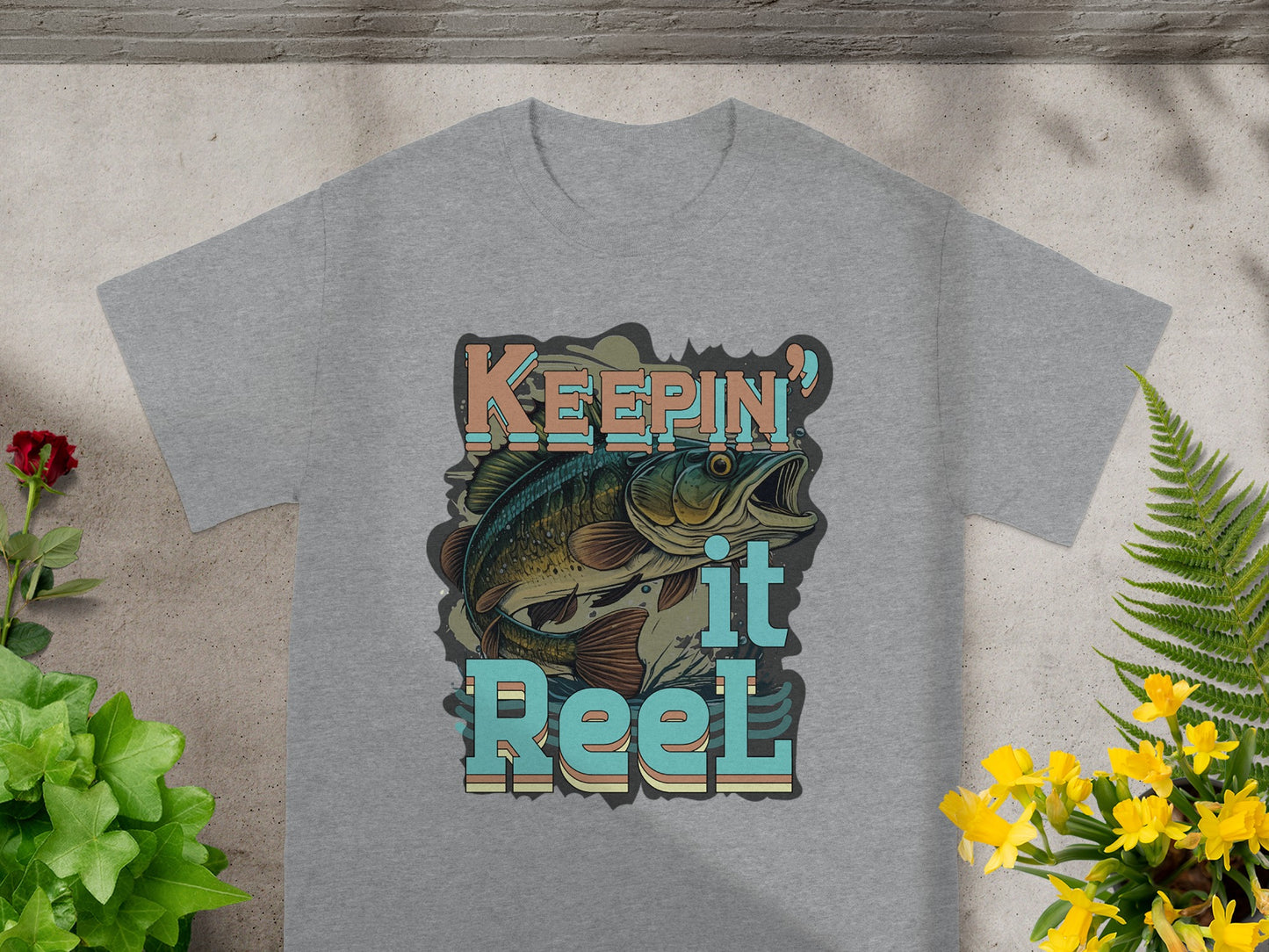 Grey t-shirt with graphic "Keepin' it Reel," featuring a bass fish.