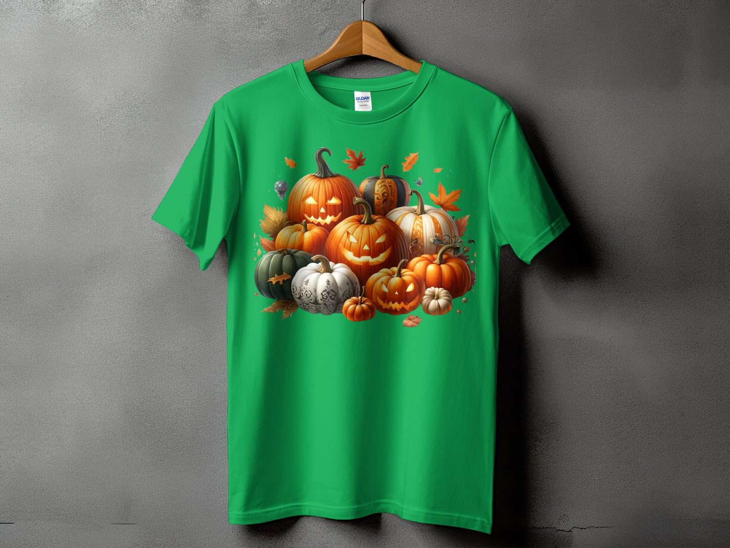 Green t-shirt featuring a cluster of carved Halloween pumpkins and autumn leaves.