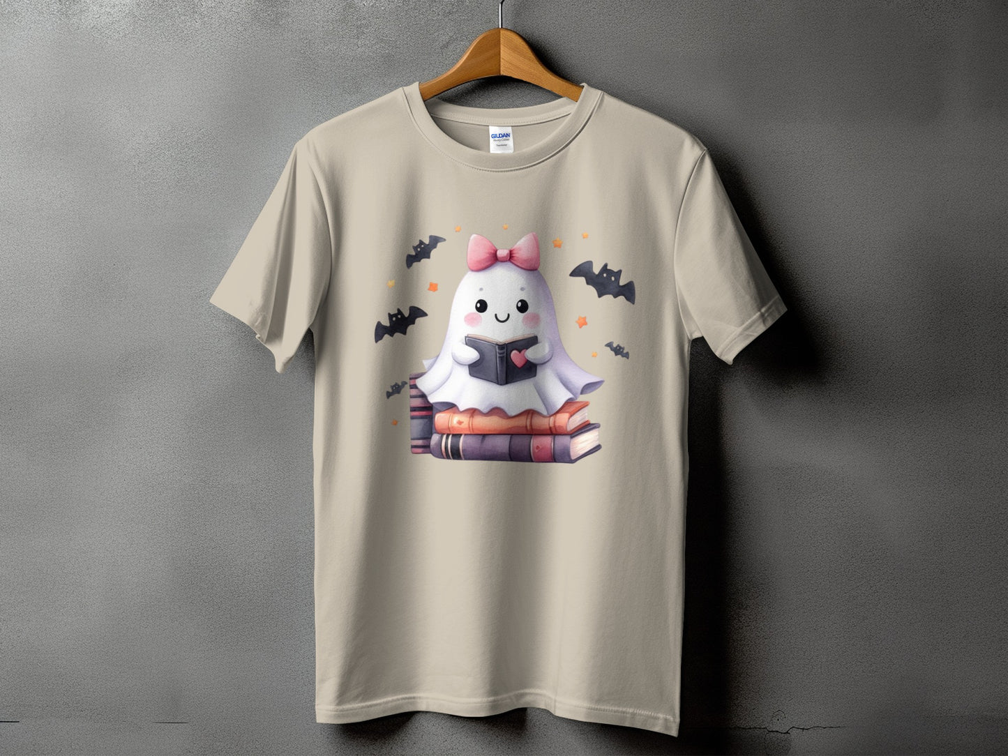 Tan t-shirt with a cute ghost reading a book, surrounded by bats.