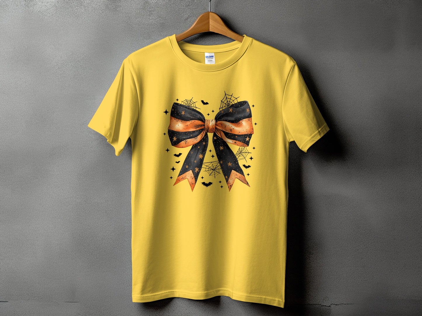 Yellow t-shirt with a black and orange Halloween bow graphic.