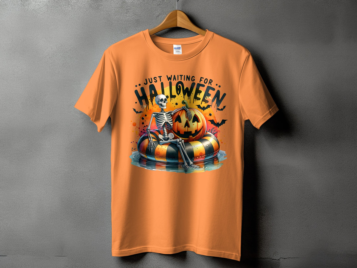 Orange t-shirt with skeleton, pumpkin, and bats graphic that says "Just Waiting For Halloween."