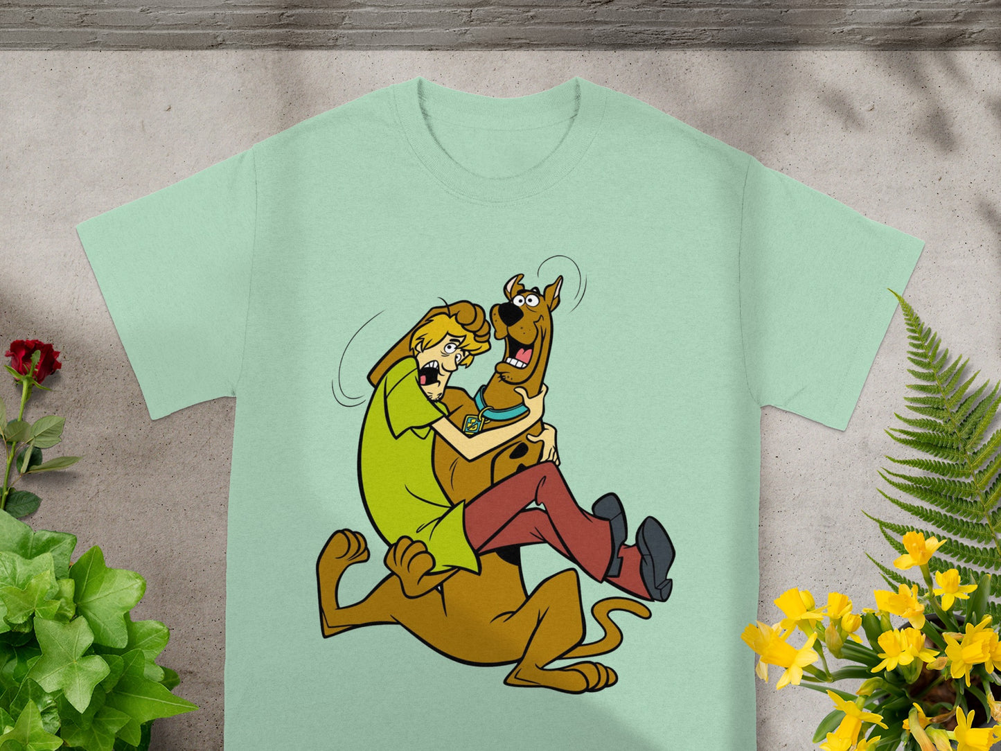 Shaggy and Scooby-Doo in a cartoon embrace on a pale green t-shirt.