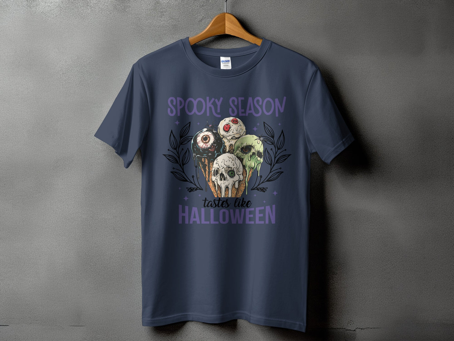 Dark blue t-shirt with "Spooky Season tastes like Halloween" and creepy ice cream cone graphic.