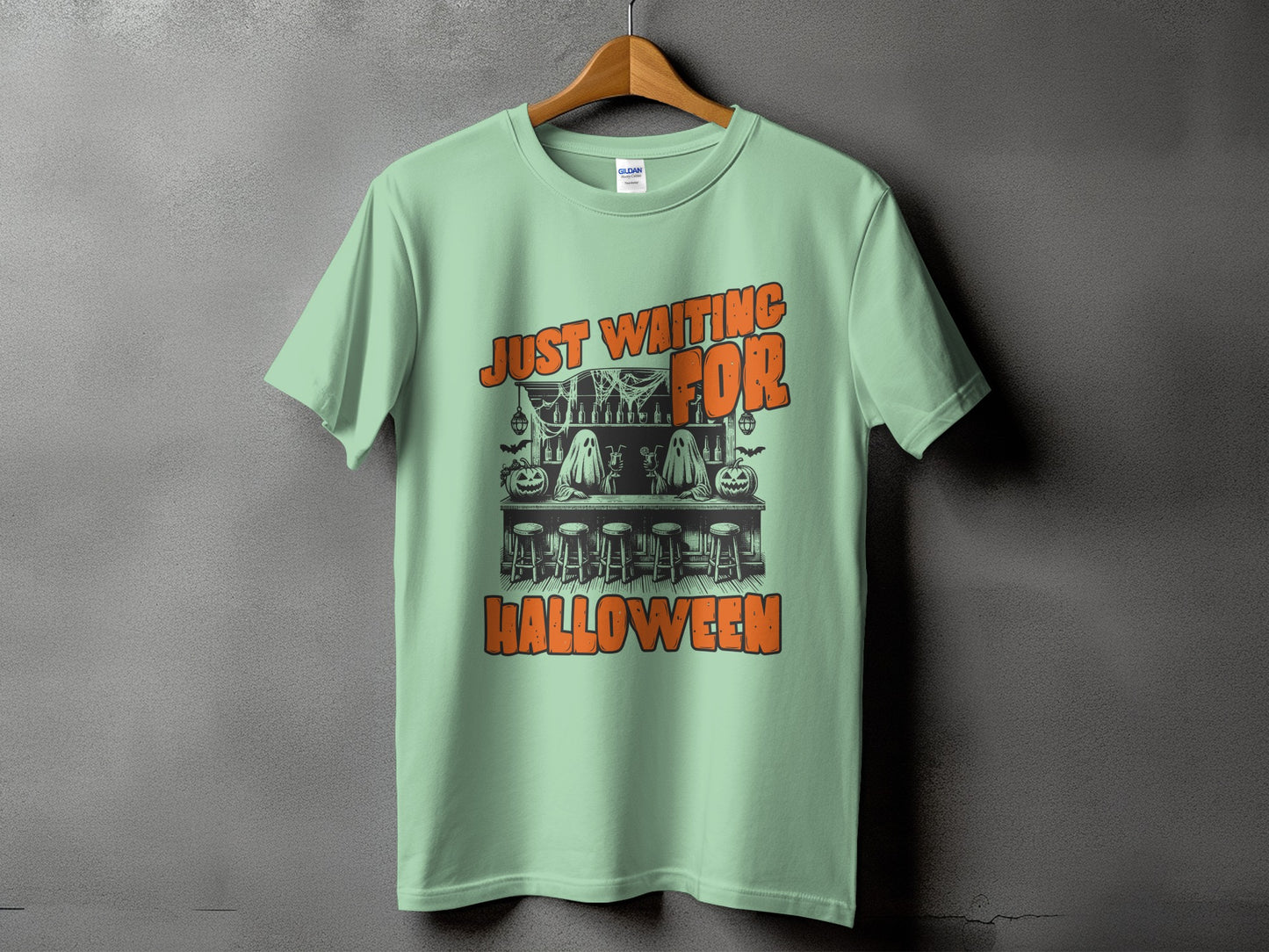 Light green t-shirt with "JUST WAITING FOR HALLOWEEN" graphic featuring ghosts and pumpkins.